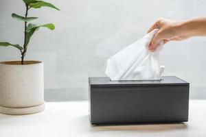 main tirant du papier toilette dans la salle de bain. concept de nettoyage, de style de vie et d'hygiène personnelle photo