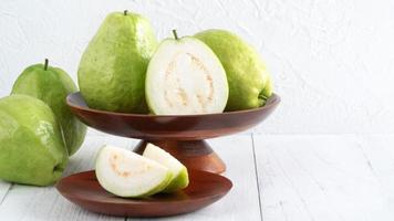 délicieux fruits de goyave sur fond de table en bois blanc avec espace de copie. photo