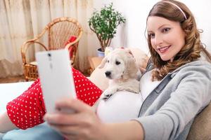 femme enceinte avec son chien à la maison photo