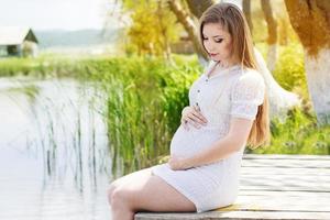 femme enceinte, séance, sur, pont, près, rivière photo