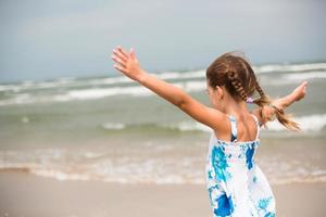 portrait d'une jeune fille au bord de la mer. l'enfant aime les vagues, se détendre sur la plage, voyager. photo