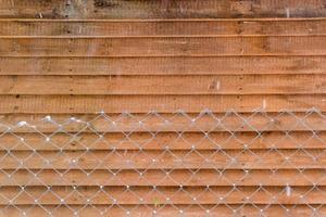 mur de bâtiment en bois et fond de clôture métallique photo