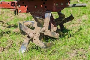 gros plan de la charrue du tracteur à poignée pour labourer le sol, matériel agricole photo