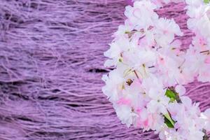 branches artificielles de pommier en fleurs sur fond de broussailles violettes photo