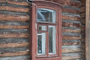 petite fenêtre dans le mur de la vieille maison en bois photo