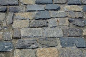 texture de la chaussée en pierre de granit. arrière-plan abstrait de l'ancien gros plan de la chaussée de galets.