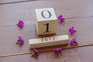 premier jour de juillet, arrière-plan coloré avec calendrier et fleurs roses photo
