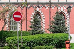 Circulaire rouge aucun panneau d'arrêt d'entrée avec une ligne horizontale blanche sur le mur de briques et le fond des arbres verts photo