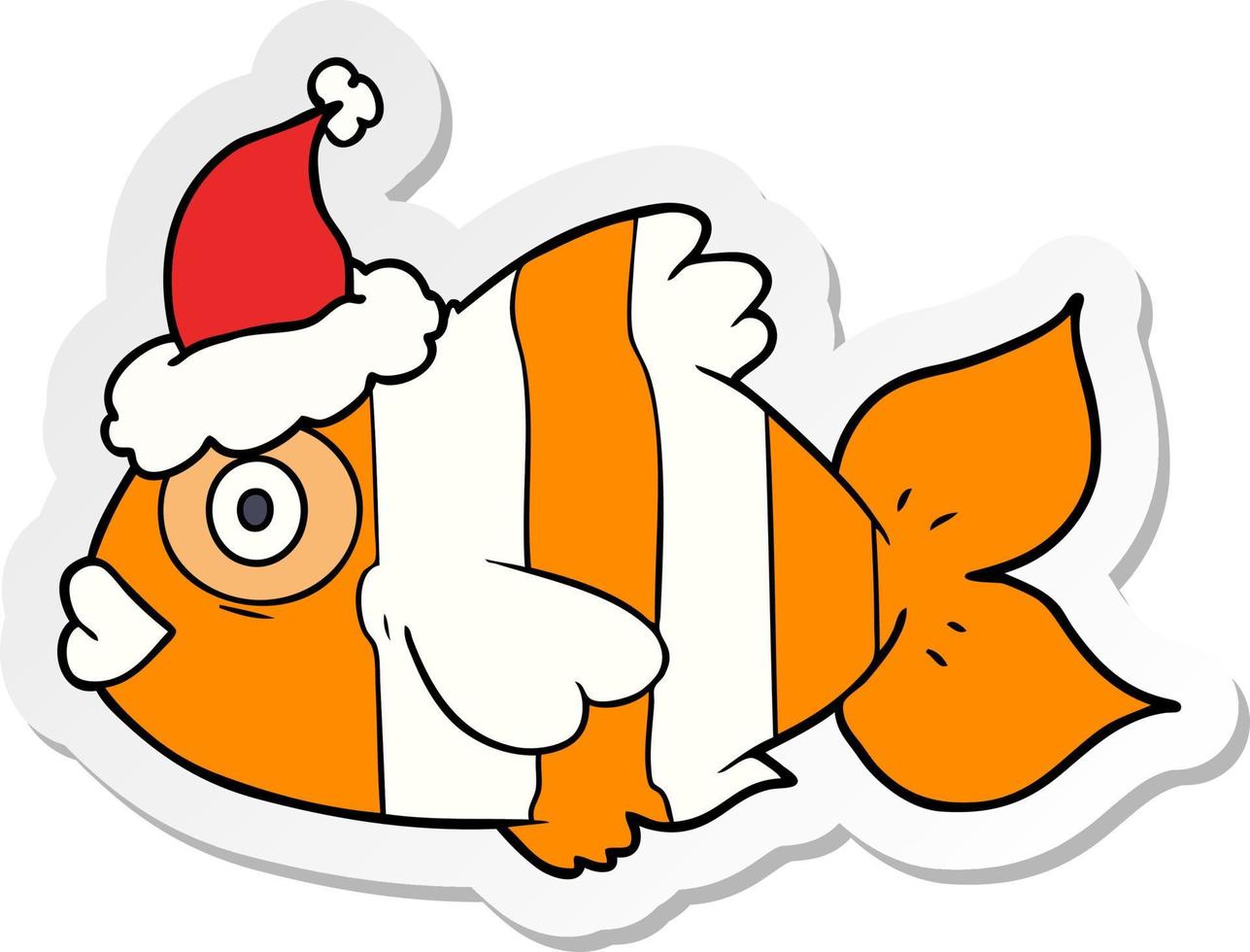 dessin animé autocollant d'un poisson exotique portant un bonnet de noel vecteur