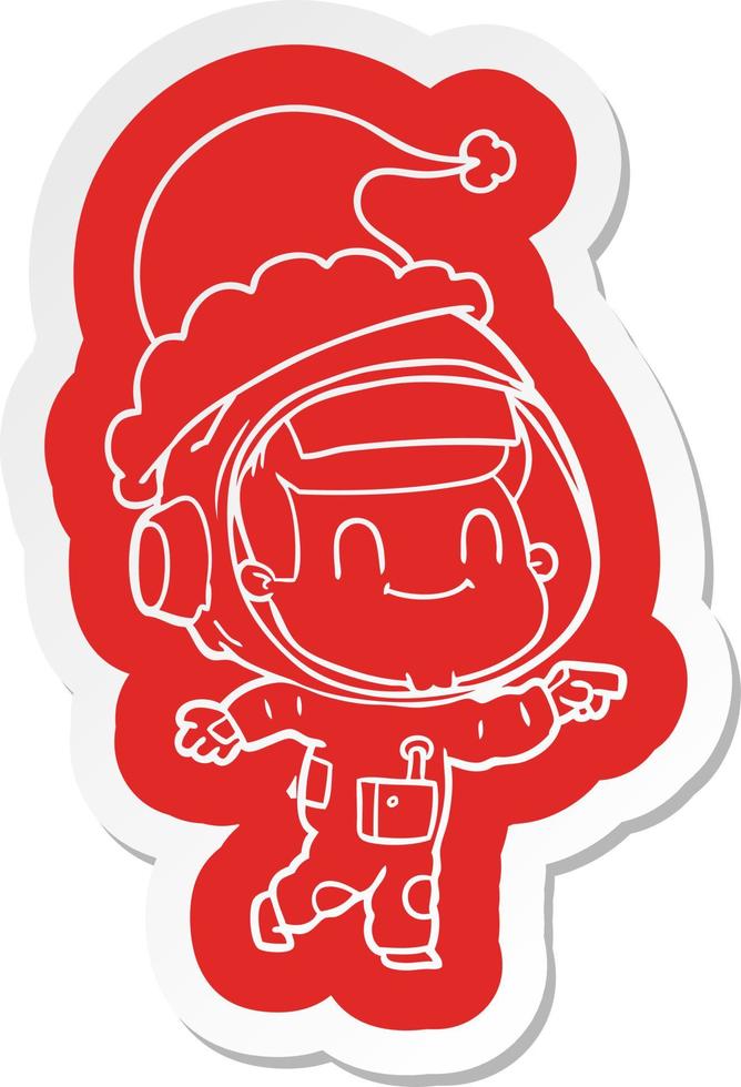 autocollant de dessin animé heureux d'un astronaute portant un bonnet de noel vecteur