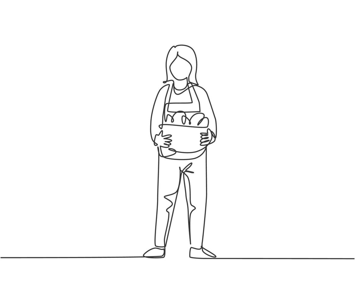 une seule ligne continue dessinant une jeune agricultrice debout sur un champ de ferme et apportant un panier plein de fruits. concept de minimalisme agricole. dynamique une ligne dessiner illustration vectorielle de conception graphique. vecteur