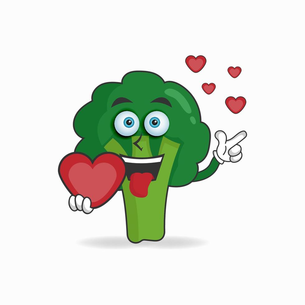 personnage de mascotte de brocoli tenant une icône d'amour. illustration vectorielle vecteur