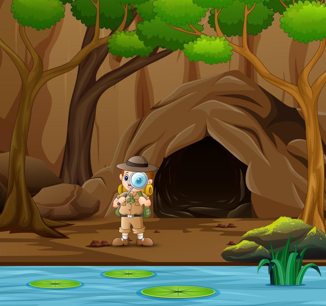 garçon explorateur debout près de la grotte et de la rivière vecteur