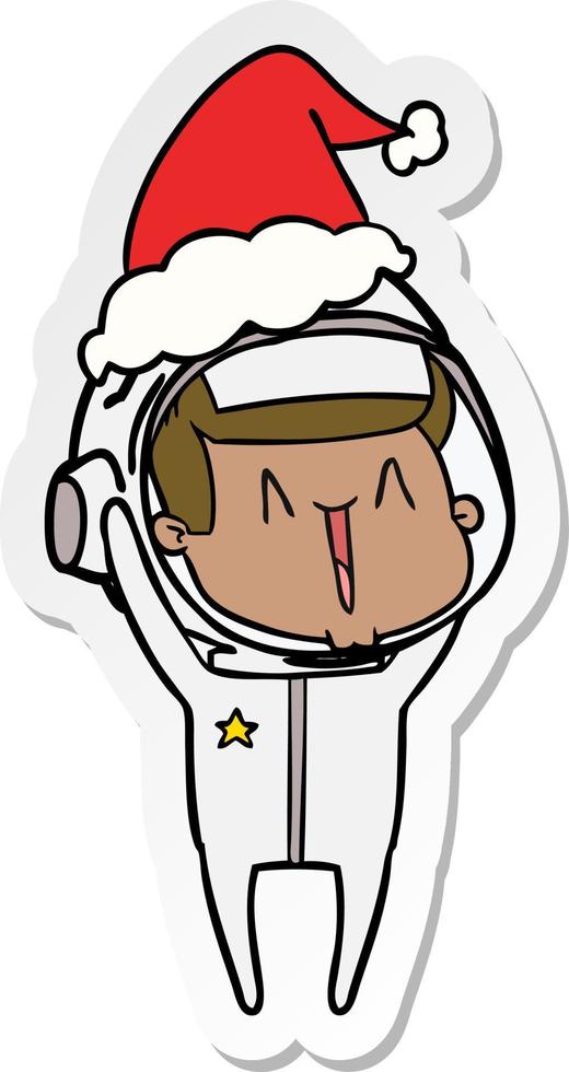 dessin animé autocollant heureux d'un astronaute portant un bonnet de noel vecteur