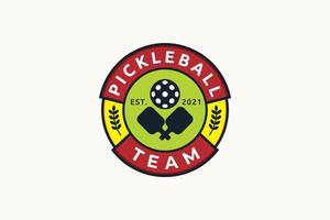 logo de l'équipe de pickleball avec combinaison d'une balle et de pagaies vecteur