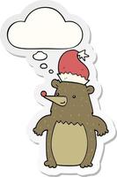 ours en dessin animé portant un chapeau de noël et une bulle de pensée sous forme d'autocollant imprimé vecteur