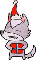 dessin animé texturé d'un loup avec un cadeau portant un bonnet de noel vecteur