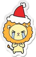 dessin animé autocollant d'un lion qui pleure portant un bonnet de noel vecteur