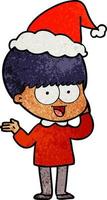 dessin animé texturé heureux d'un garçon portant un bonnet de noel vecteur