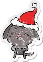 dessin animé autocollant en détresse heureux d'un chien portant un bonnet de noel vecteur