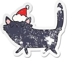 dessin animé autocollant en détresse d'un chat noir portant un bonnet de noel vecteur