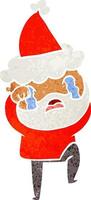 dessin animé rétro d'un homme barbu pleurant et frappant du pied portant un bonnet de noel vecteur