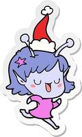 dessin animé autocollant fille extraterrestre heureuse d'un bonnet de noel vecteur