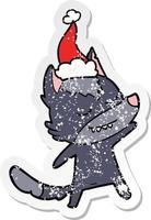 dessin animé amical d'autocollant en détresse d'un loup portant un bonnet de noel vecteur