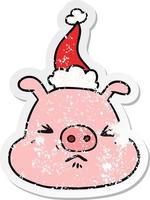 dessin animé autocollant en détresse d'un visage de cochon en colère portant un bonnet de noel vecteur