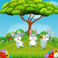 la belle vue avec trois lapins jouant ensemble sous l'immense arbre vecteur