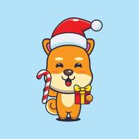 mignon chien shiba inu tenant des bonbons et des cadeaux de noël. illustration de dessin animé de noël mignon. vecteur