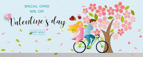 un couple fait du vélo avec des fleurs de beaux arbres et des feuilles soufflées dans le vent et les promotions de la saint-valentin offrent un libellé de vente sur fond de papier bleu. le tout dans un style plat et un design vectoriel. vecteur