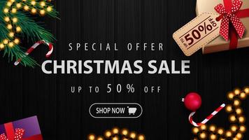 offre spéciale, vente de Noël, jusqu'à 50 de réduction, bannière de réduction avec des cadeaux, arbre de Noël, boîtes de bonbons et texture de bois noir sur le fond vecteur