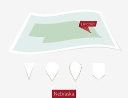 incurvé papier carte de Nebraska Etat avec Capitale Lincoln sur gris Contexte. quatre différent carte épingle ensemble. vecteur