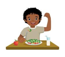 mignonne peu africain garçon en mangeant brocoli en bonne santé des légumes avec fourchette montrant poing fort muscle vecteur