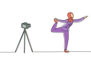 une seule ligne continue dessinant une blogueuse arabe en tenue de sport hijab tourne une vidéo sur la caméra en faisant des exercices à la maison. fitness vlogger diffusion en direct de la séance d'entraînement. vecteur de conception de dessin d'une ligne