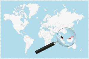 grossissant verre montrant une carte de Malaisie sur une monde carte. vecteur