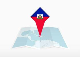 Haïti est représenté sur une plié papier carte et épinglé emplacement marqueur avec drapeau de Haïti. vecteur