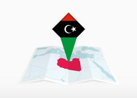 Libye est représenté sur une plié papier carte et épinglé emplacement marqueur avec drapeau de Libye. vecteur