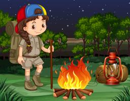 Petite fille debout près du feu de camp vecteur