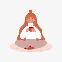 femme dans un chandail chaud boit du café thé chocolat chaud tout en étant assise sur le tapis vecteur