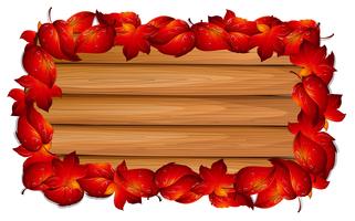 Planche de bois avec des feuilles rouges à la frontière vecteur