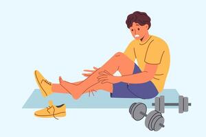 blessé sportif est assis sur tapis pour des sports près haltères, après élongation muscles sur jambes vecteur