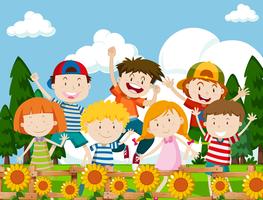 Enfants heureux dans un jardin de fleurs vecteur
