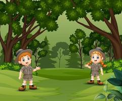 enfants scouts heureux parlant et explorant la forêt vecteur