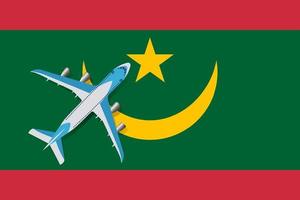 illustration vectorielle d'un avion de passagers survolant le drapeau de la mauritanie. concept de tourisme et de voyage vecteur