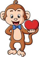 le singe mignon est prêt pour la saint valentin et tient la poupée coeur