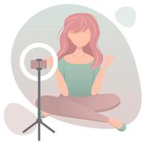 jeune fille à la mode assise sur le sol et faisant de la beauté vidéo ou critique pour la chaîne vlog. lampe et téléphone sur trépied. illustration plate de vecteur. vecteur