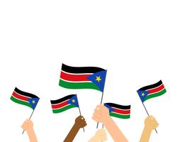 Illustration vectorielle de mains tenant des drapeaux du Sud-Soudan isolés sur fond blanc vecteur