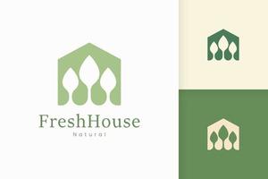 logo de maison verte nature avec forme d'arbre et de feuille vecteur